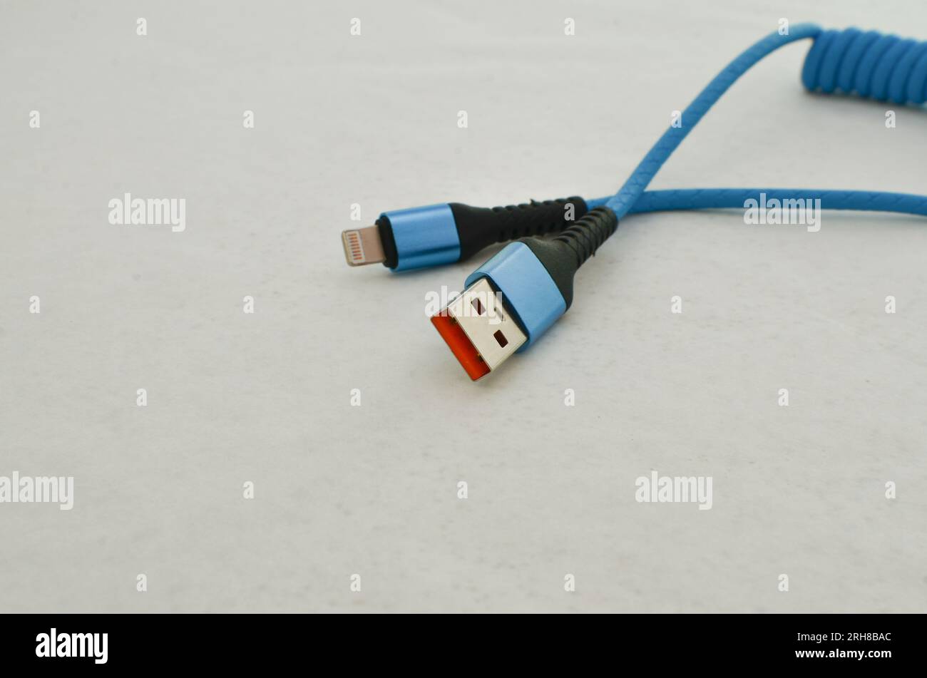 Dettagli del collegamento del cavo USB Apple evidenziati su una superficie leggera, perfetti per i moderni concetti tecnologici. Cavo che fornisce velocità e trasferimento dati. Foto Stock