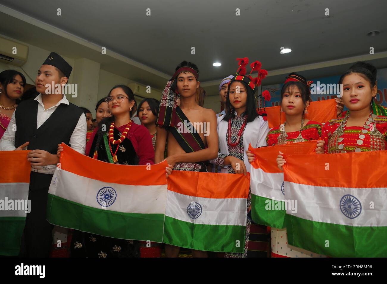 Ragazze indigene che hanno la bandiera nazionale durante un programma culturale in occasione della giornata Mondiale degli indigeni in un auditorium di Agartala. Tripura. India. Foto Stock