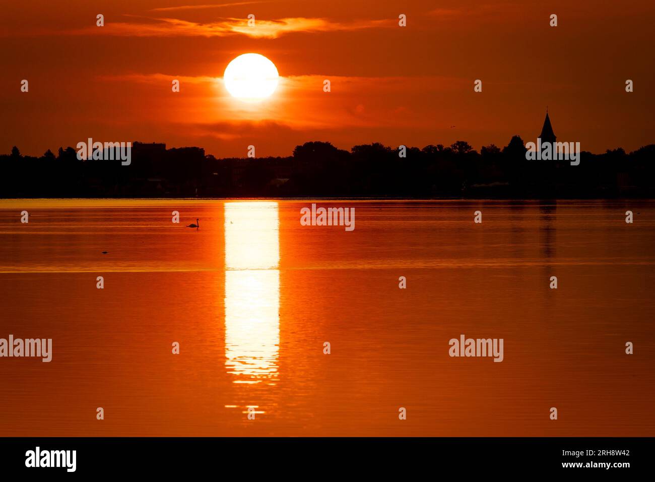 Hagenburg, Germania. 15 agosto 2023. Il sole sorge sullo Steinhuder Meer nella regione di Hannover. Credito: Moritz Frankenberg/dpa/Alamy Live News Foto Stock