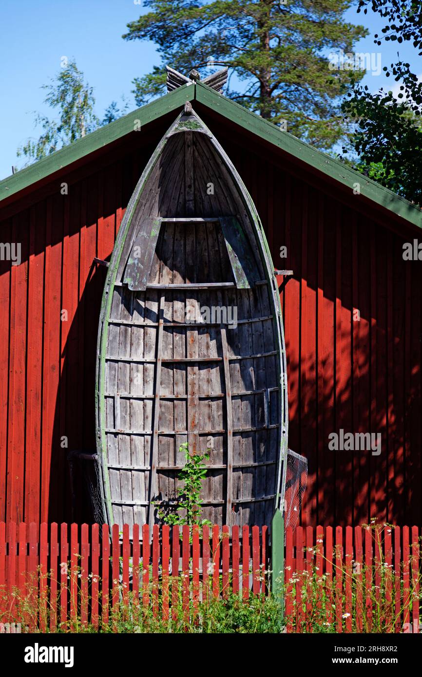 grande vecchia barca di legno appoggiata contro il muro della casa Foto Stock