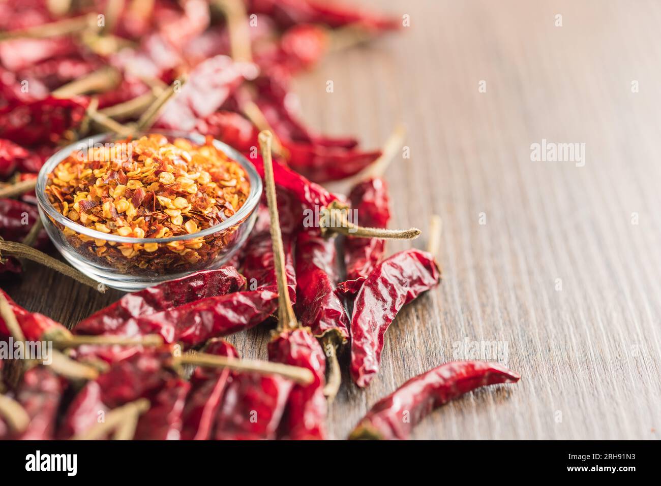 Peperoncino tritato e peperoncino intero nel recipiente. Foto Stock