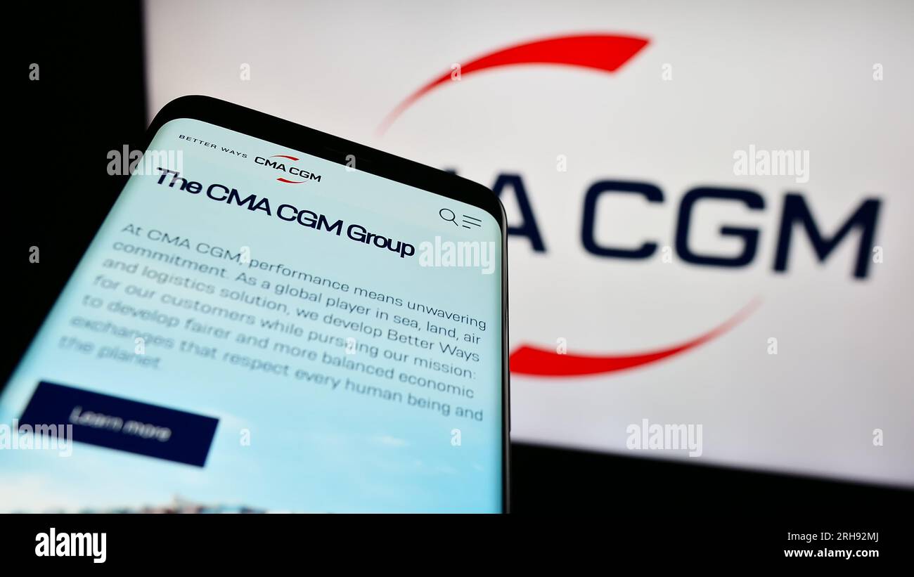 Telefono cellulare con sito web della società di logistica francese CMA CGM S.A. sullo schermo davanti al logo aziendale. Mettere a fuoco in alto a sinistra sul display del telefono. Foto Stock