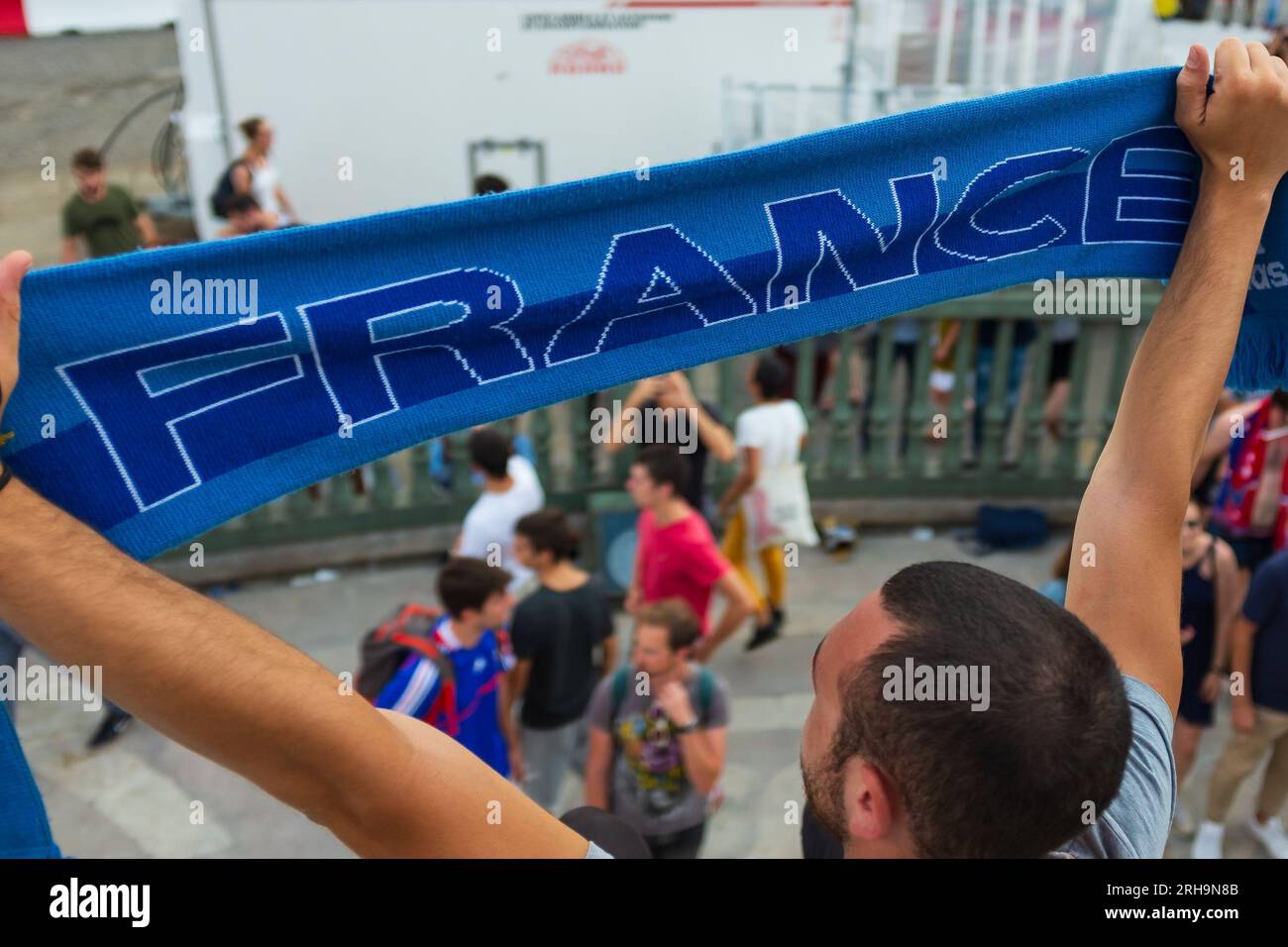 Parigi, Francia, 2018. In piedi sulla colonna di luglio, un giovane uomo sta tenendo in mano una sciarpa blu che dice, Francia, per celebrare la Coppa del mondo di calcio 2018 Foto Stock