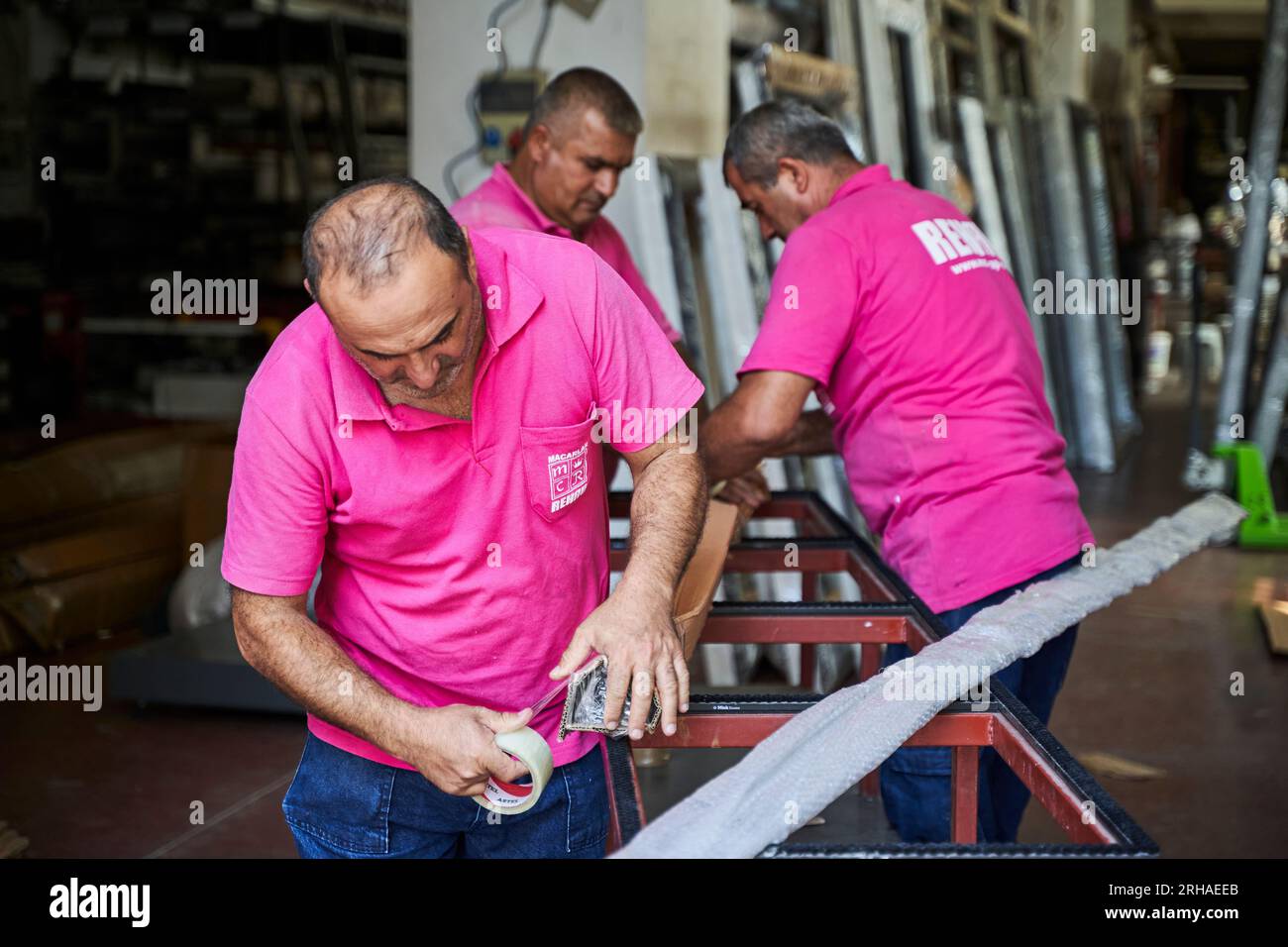 Lavoratori che imballano la scatola di cartone in magazzino per la spedizione. un operatore chiude una scatola di cartone con nastro adesivo in un magazzino. Foto Stock