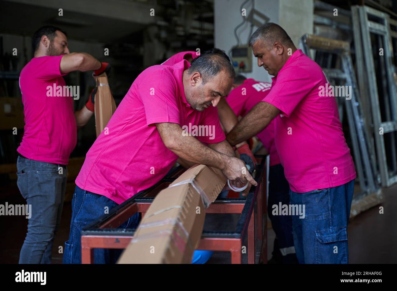 Lavoratori che imballano la scatola di cartone in magazzino per la spedizione. un operatore chiude una scatola di cartone con nastro adesivo in un magazzino. Foto Stock