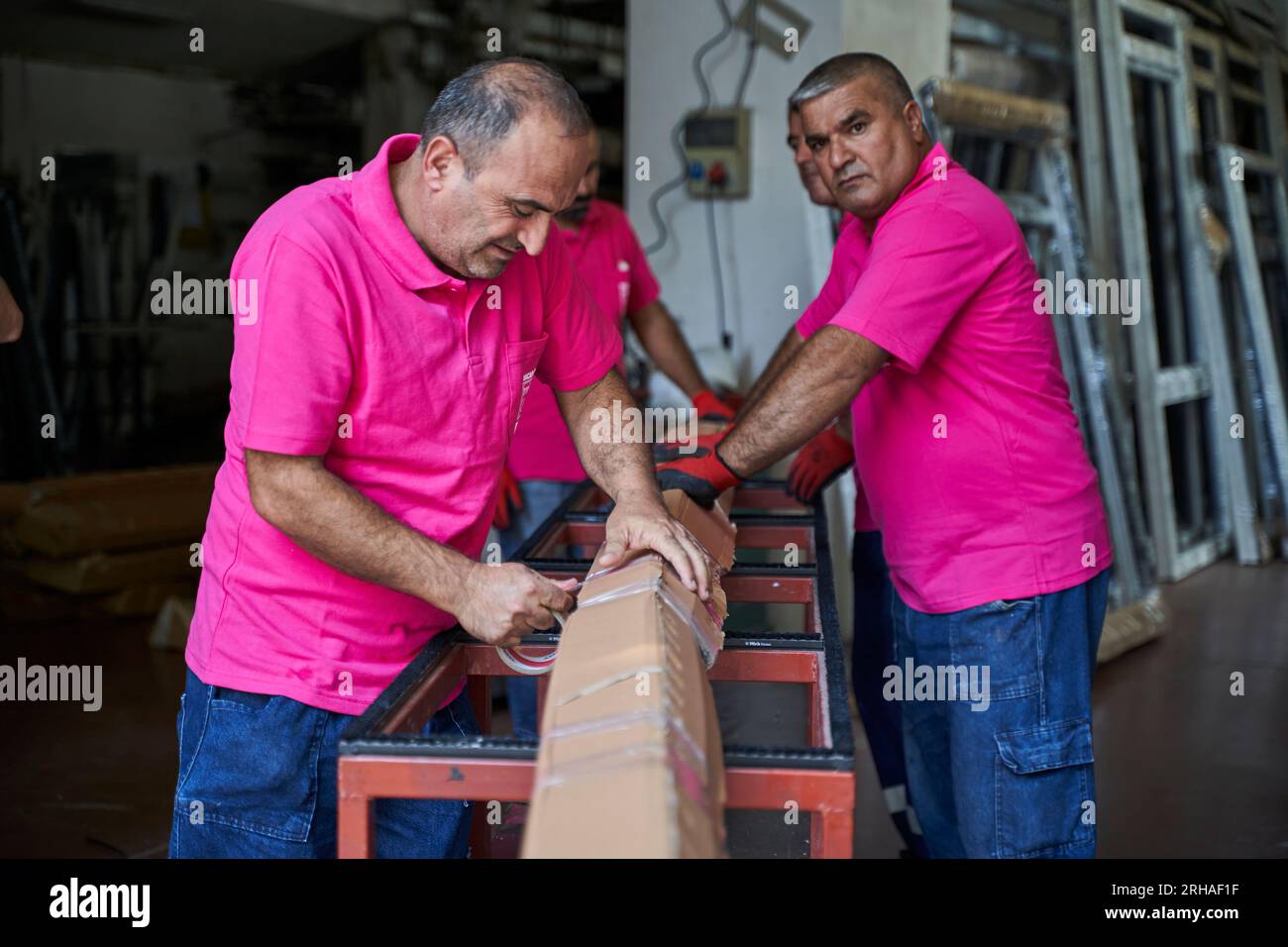 Lavoratori che imballano la scatola di cartone in magazzino per la spedizione. un operatore chiude una scatola di cartone con nastro adesivo in un magazzino. Foto Stock