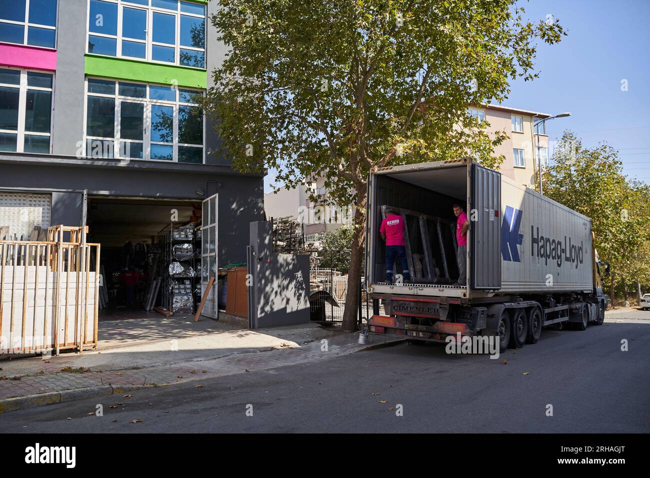 Lavoratori che confezionano fogli di vetro in magazzino. lavoratore che spedisce la finestra in vetro. lavoratore che indossa giubbotto di sicurezza e casco. Foto Stock