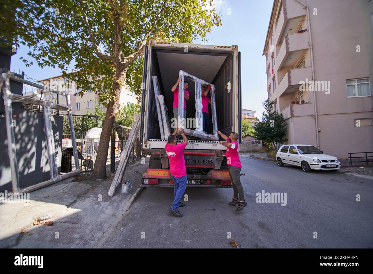 Lavoratori che confezionano fogli di vetro in magazzino. lavoratore che spedisce la finestra in vetro. lavoratore che indossa giubbotto di sicurezza e casco. Foto Stock
