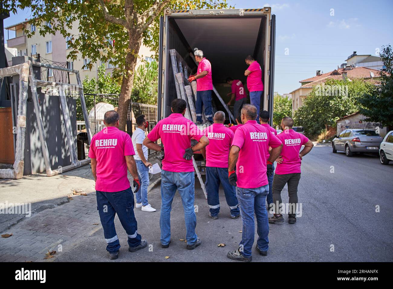 Lavoratori che confezionano fogli di vetro in magazzino. lavoratore che spedisce la finestra in vetro. lavoratore che indossa giubbotto di sicurezza e casco. Foto Stock