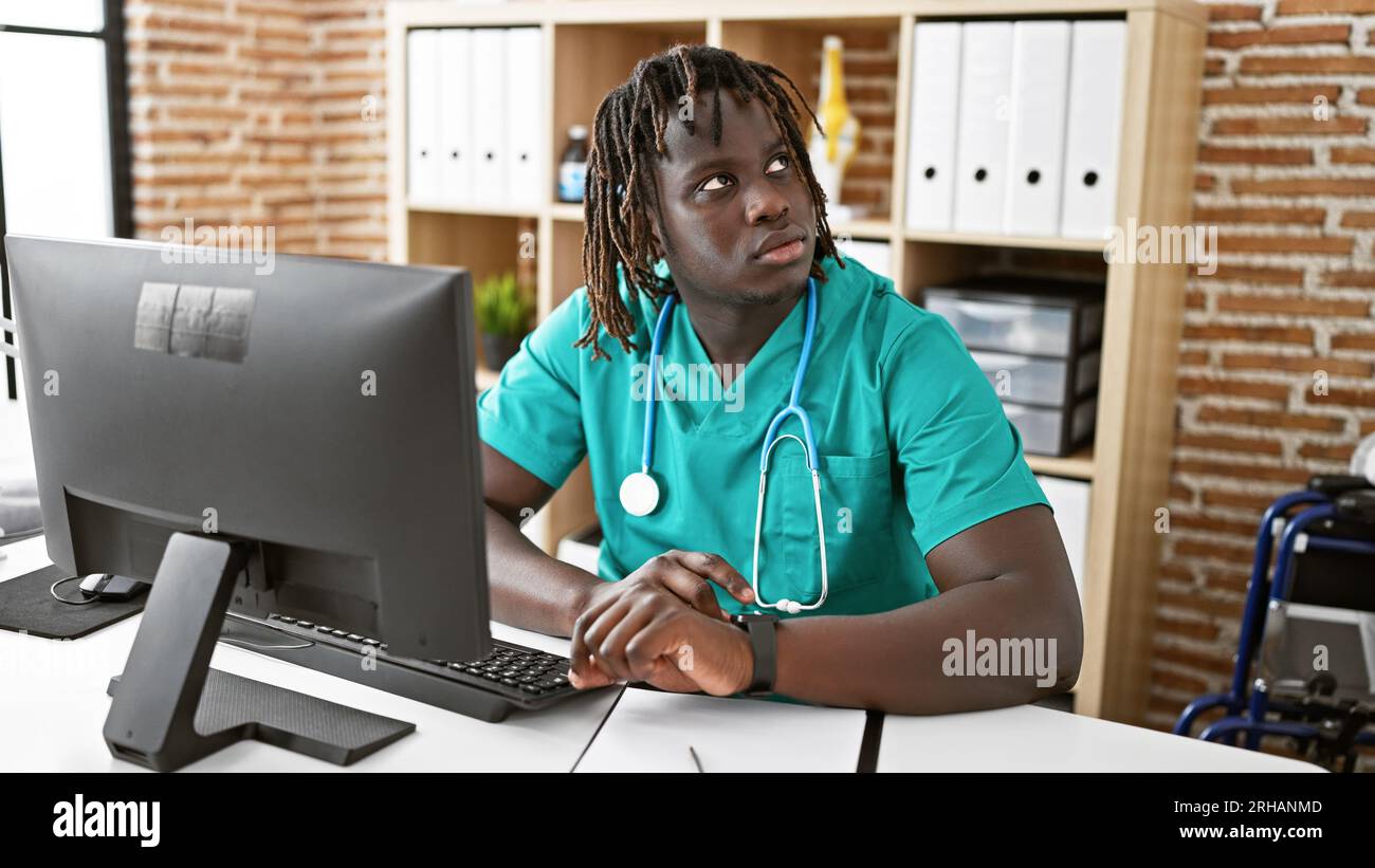 afroamericano uomo medico che usa computer che lavora alla clinica Foto Stock