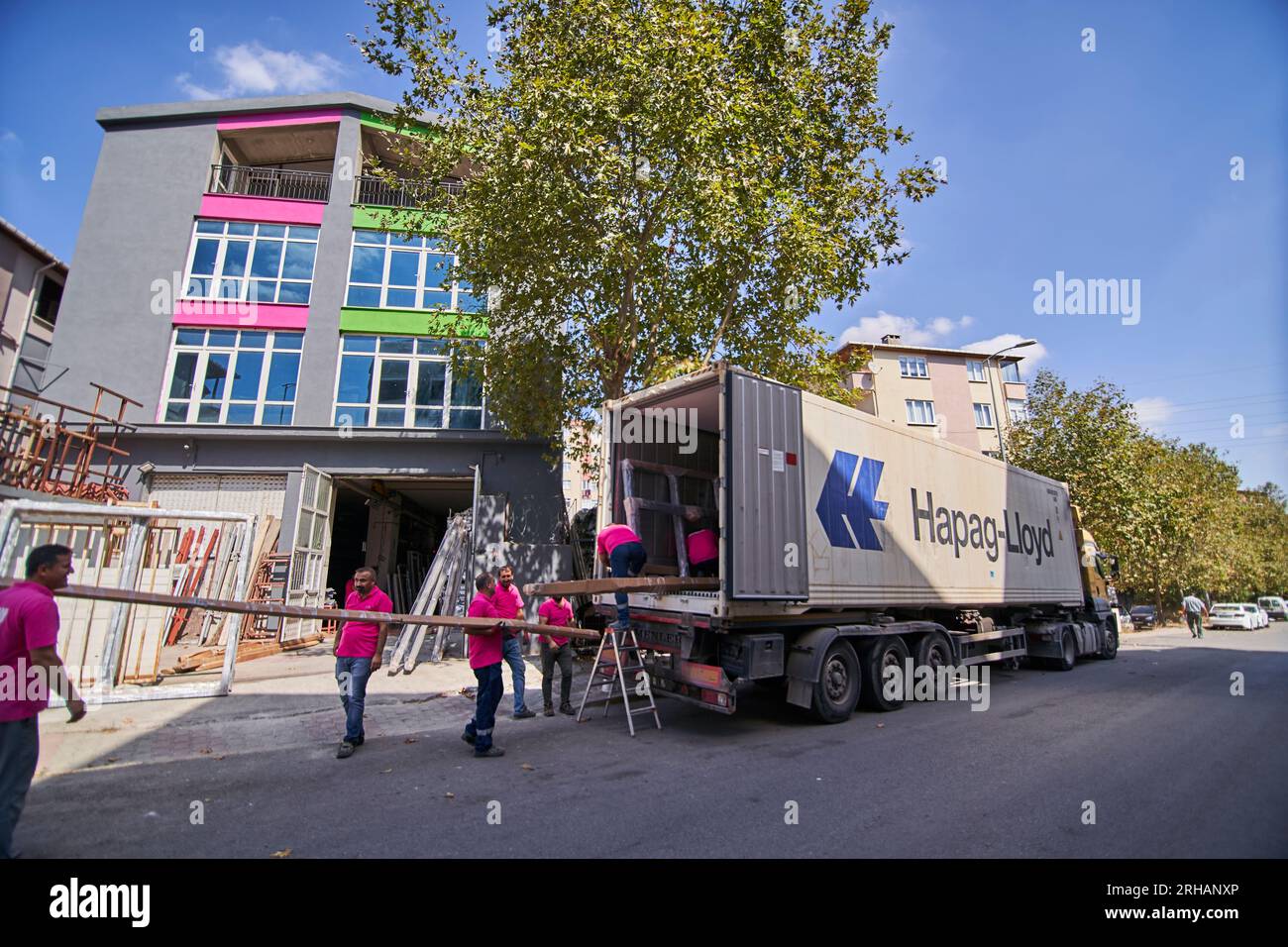 Lavoratori che confezionano fogli di vetro in magazzino. lavoratore che spedisce la finestra in vetro. lavoratore che indossa giubbotto di sicurezza e casco. Foto Stock