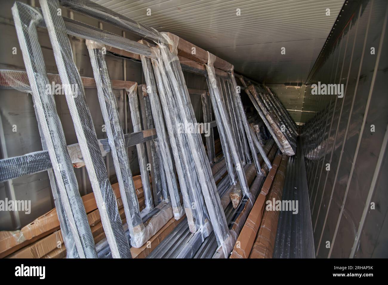 Lavoratori che confezionano fogli di vetro in magazzino. lavoratore che spedisce la finestra in vetro. lavoratore che indossa giubbotto di sicurezza e casco. Foto Stock