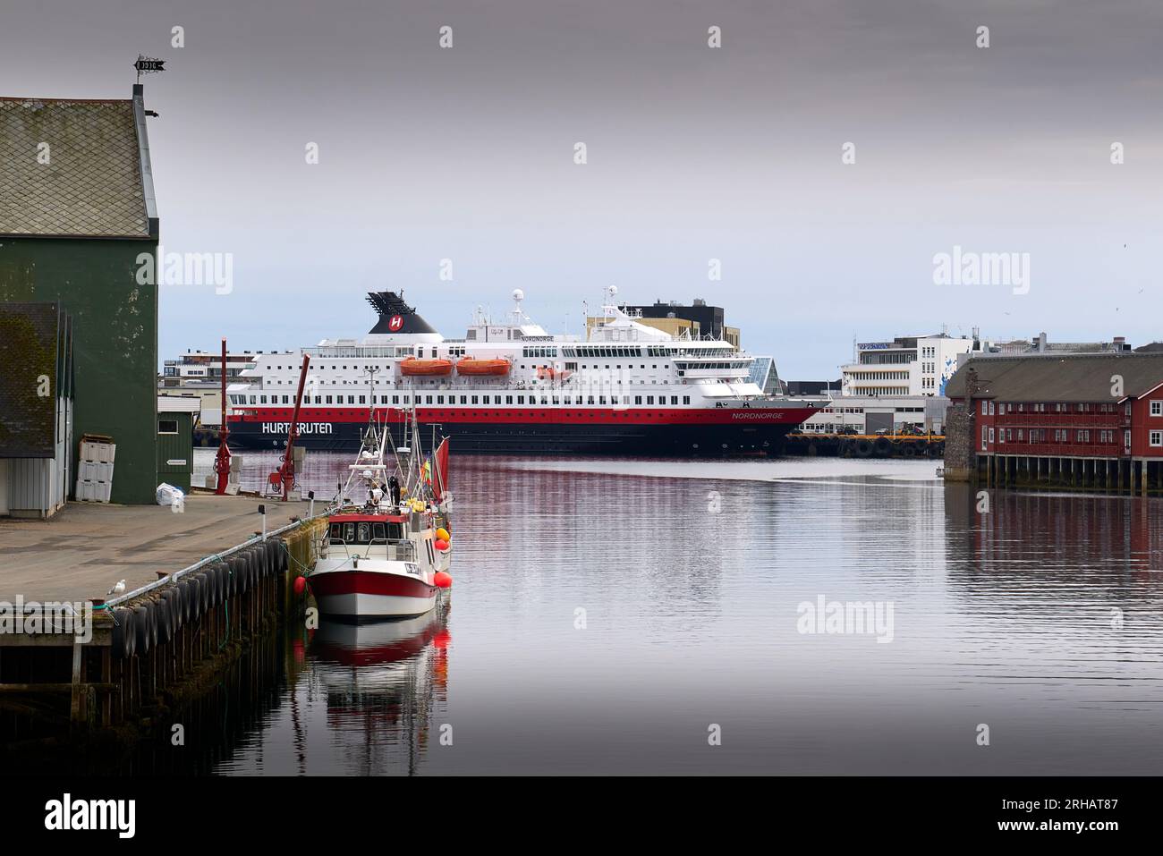 Storici magazzini norvegesi per il pesce in Foreground e il traghetto Hurtigruten, MS NORDNORGE, ormeggiati nella città di Svolvær, nelle isole Lofoten. Foto Stock