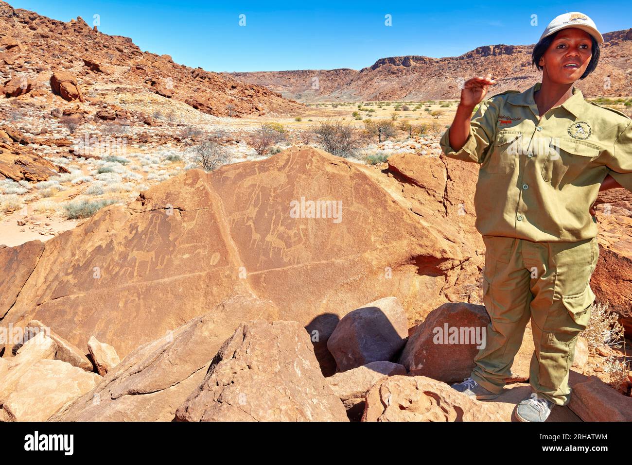 Namibia. Una guida mostra incisioni rupestri preistoriche nel sito archeologico di Twyfelfontein Foto Stock