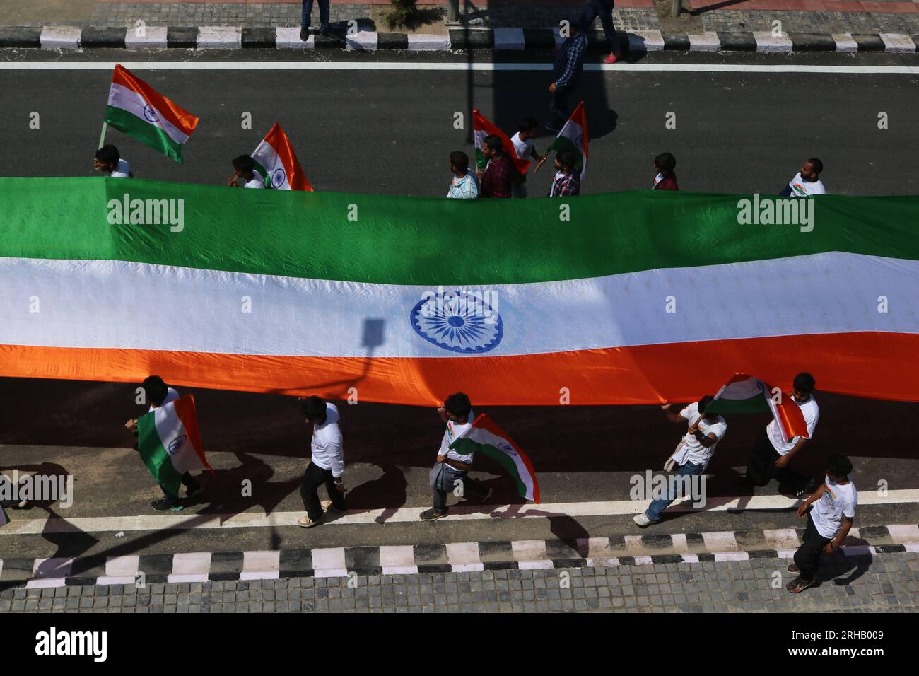 Srinagar, India. 15 agosto 2023. 15 agosto 2023, Srinagar Kashmir, India: La gente porta una gigantesca bandiera nazionale indiana durante le celebrazioni del 77° giorno dell'indipendenza dell'India a Srinagar. Il 15 agosto 2023 a Srinagar Kashmir, India. (Foto di Firdous Nazir/Eyepix Group) credito: Eyepix Group/Alamy Live News Foto Stock