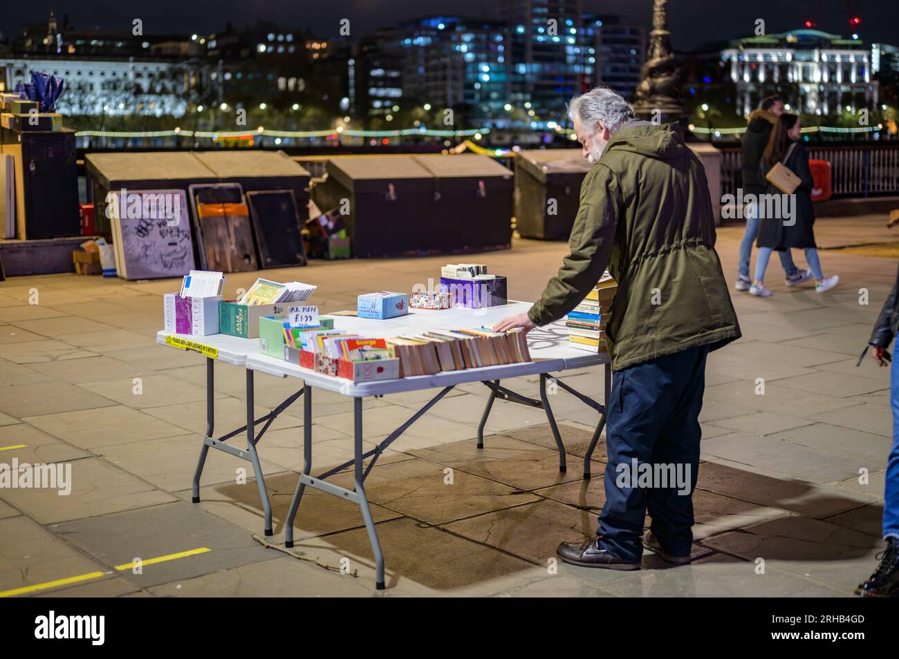 LONDRA - 22 aprile 2023: Un venditore di libri usato organizza libri d'epoca su un tavolo di Southbank, offrendo un'esperienza deliziosa per gli appassionati di letteratura ami Foto Stock