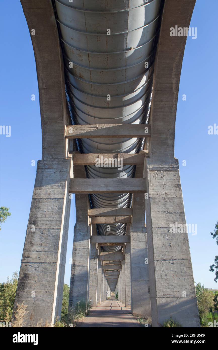 Strada di servizio che passa sotto l'Acedera Aqueduct. Canale di irrigazione Orellana, Las Vegas Altas del Guadiana, Estremadura, Spagna Foto Stock