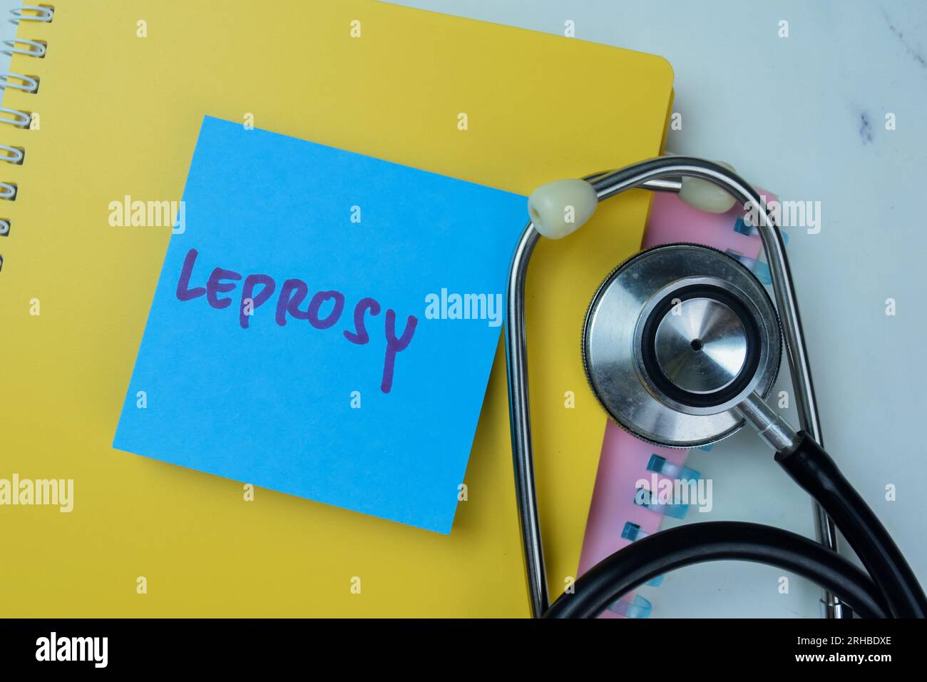 Concetto di lebbra scrivere su note adesive con stetoscopio isolato su un tavolo di legno. Foto Stock