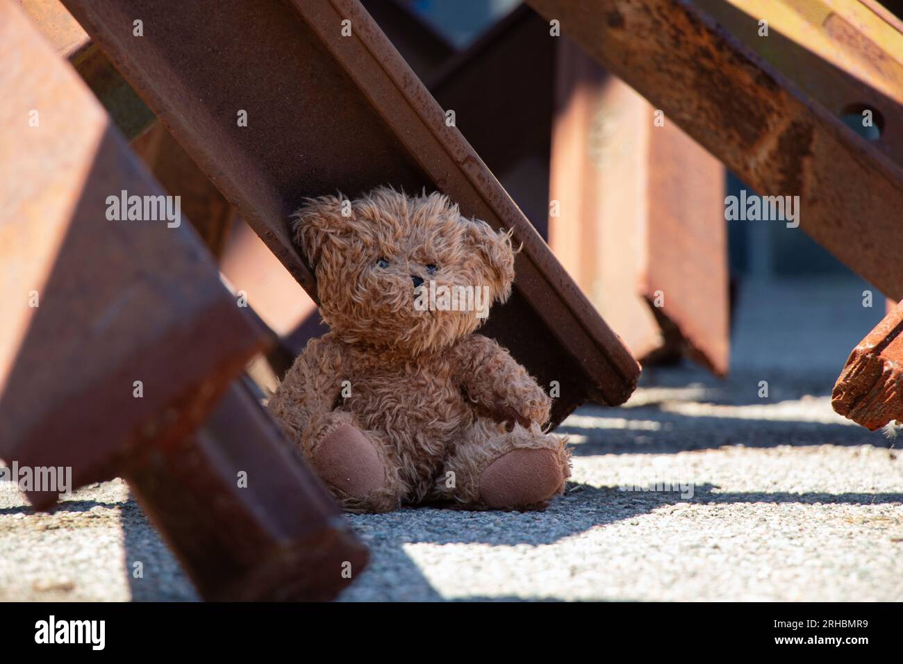 Un orsacchiotto si trova accanto a un riccio anticarro su una strada nella città di Dnipro in Ucraina durante la guerra Foto Stock