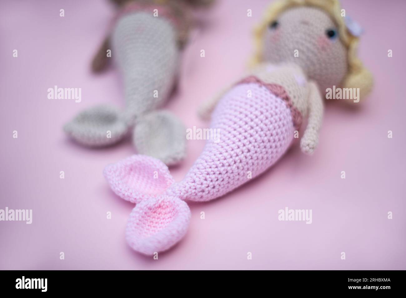 Primo piano di due sirene amigurumi all'uncinetto su sfondo rosa Foto Stock