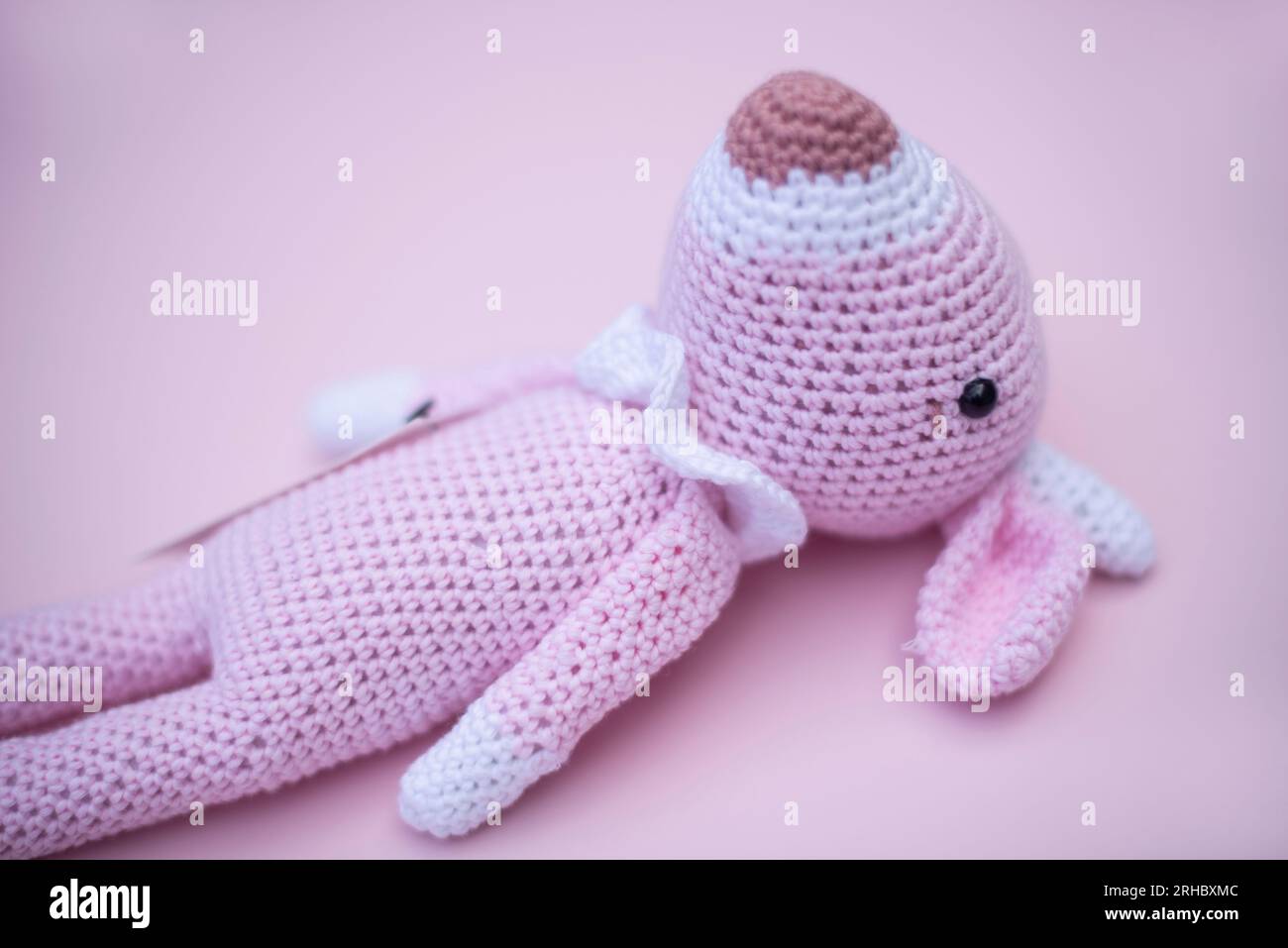 Primo piano di un giocattolo di gazzella amigurumi all'uncinetto su sfondo rosa Foto Stock