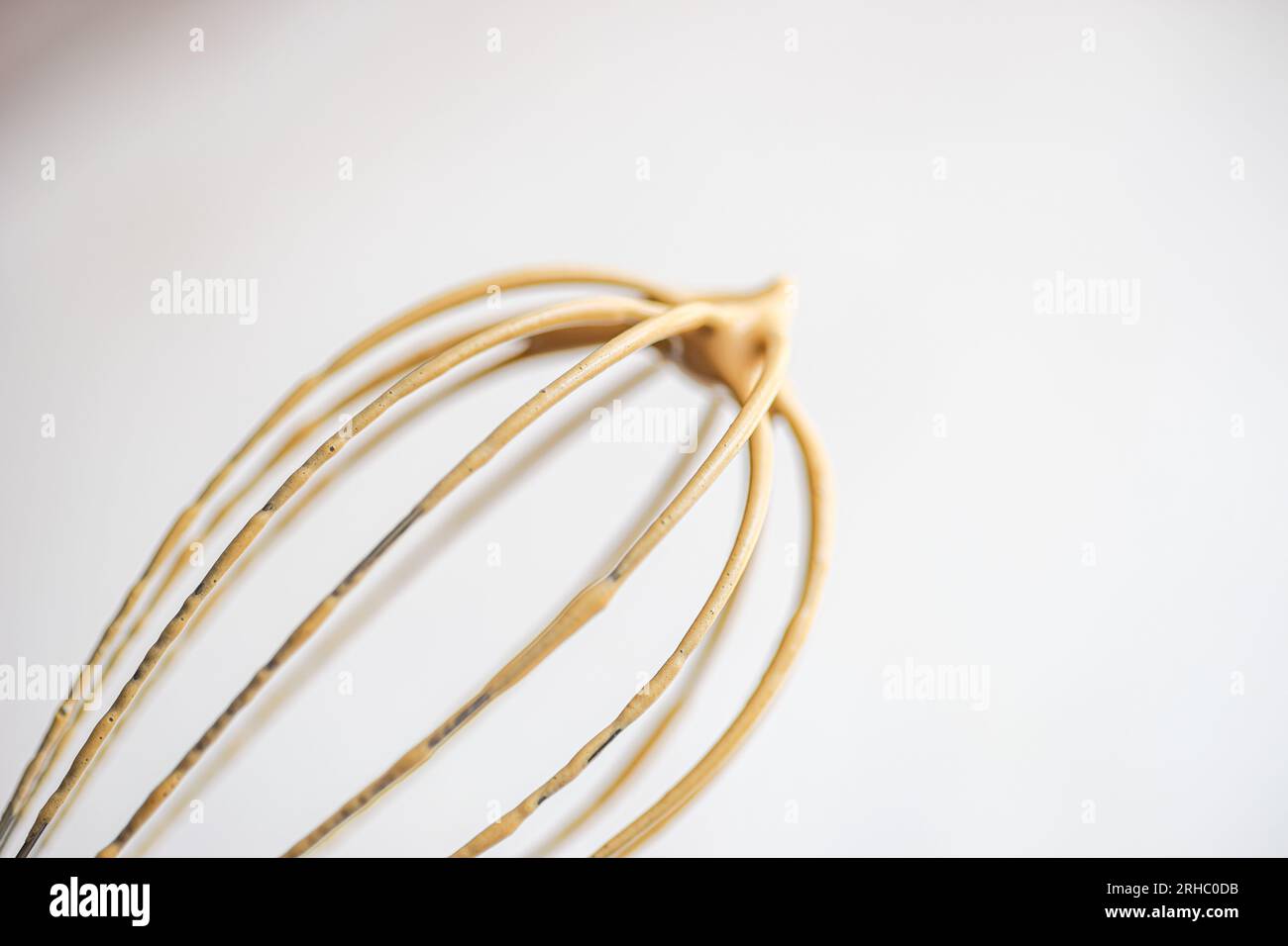 Primo piano di una frusta ricoperta di crema di caffè Foto Stock