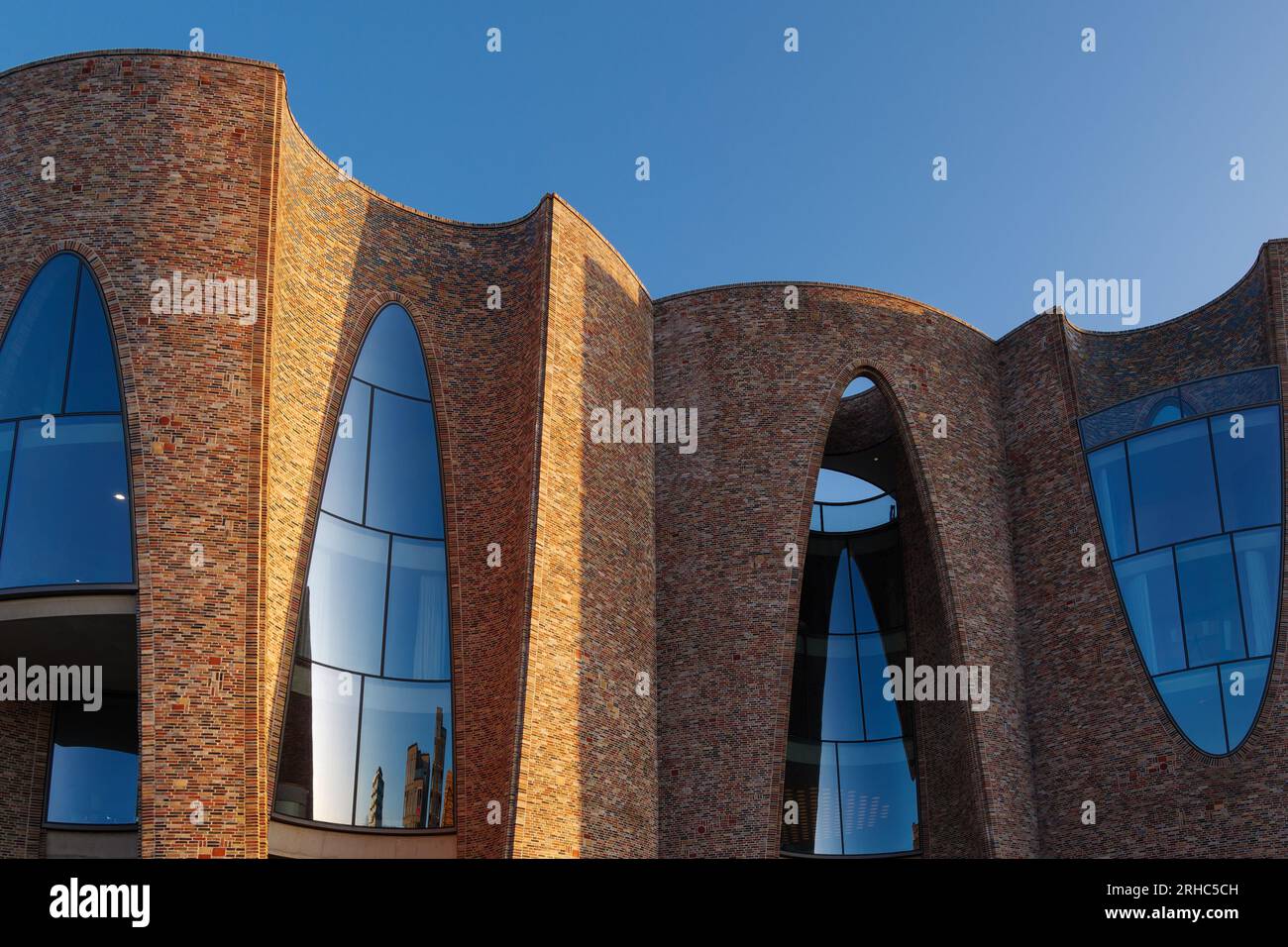 Vejle, Danimarca - 06 OTTOBRE 2022: Vista esterna esterna e dettaglio delle pareti in mattoni curvatura e delle finestre a Fjordenhus durante l'ora del tramonto. Foto Stock