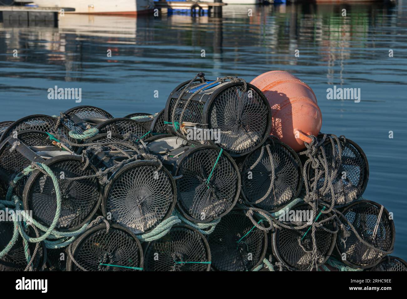 Trappole per gamberi da pesca impilate sul molo, vista ravvicinata con la luce del sole Foto Stock