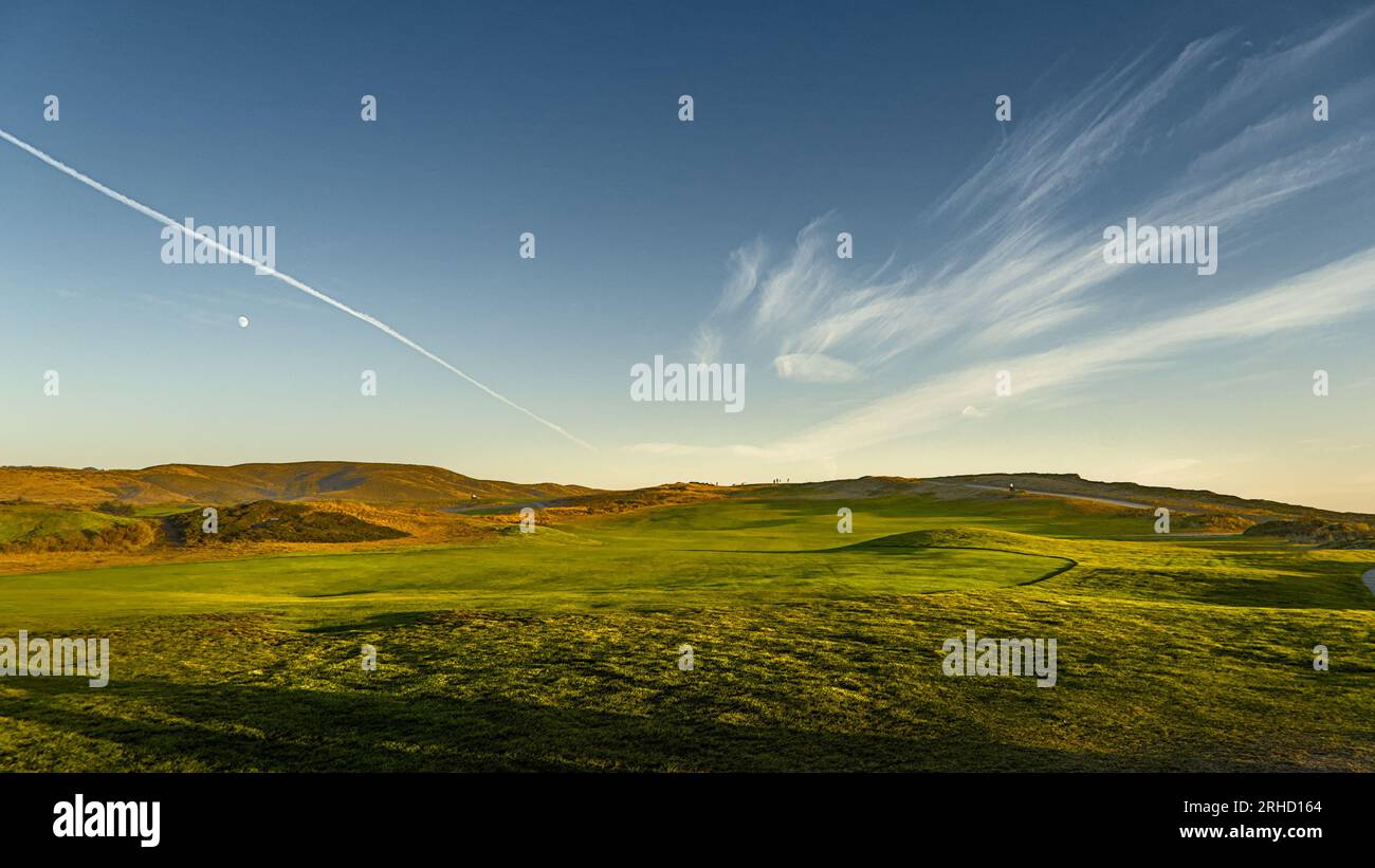 Verdi colline sotto il cielo blu all'ora dell'oro. Foto Stock