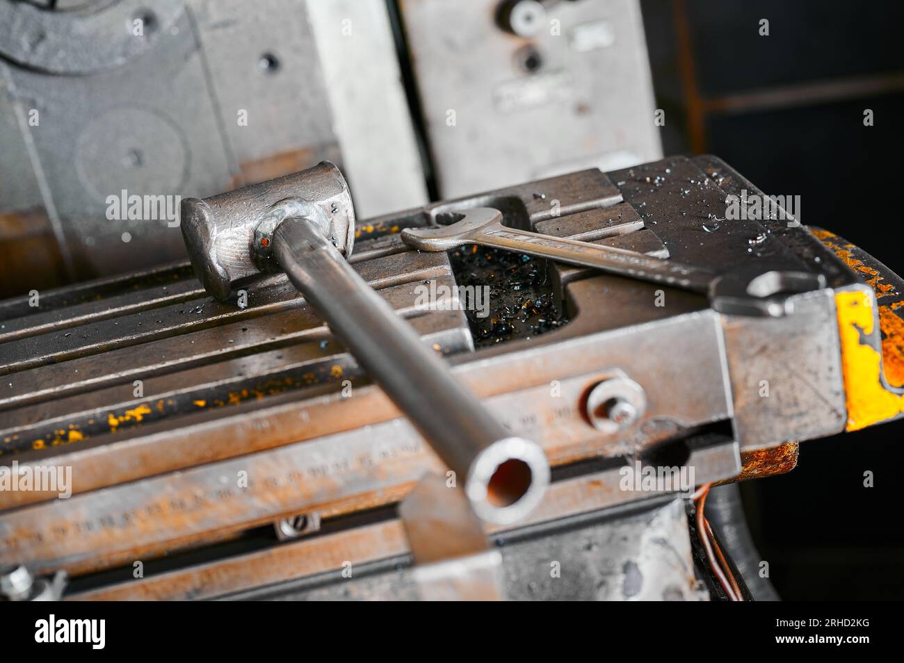 Martello in metallo e chiave su tornio utensile scorrevole in officina Foto Stock