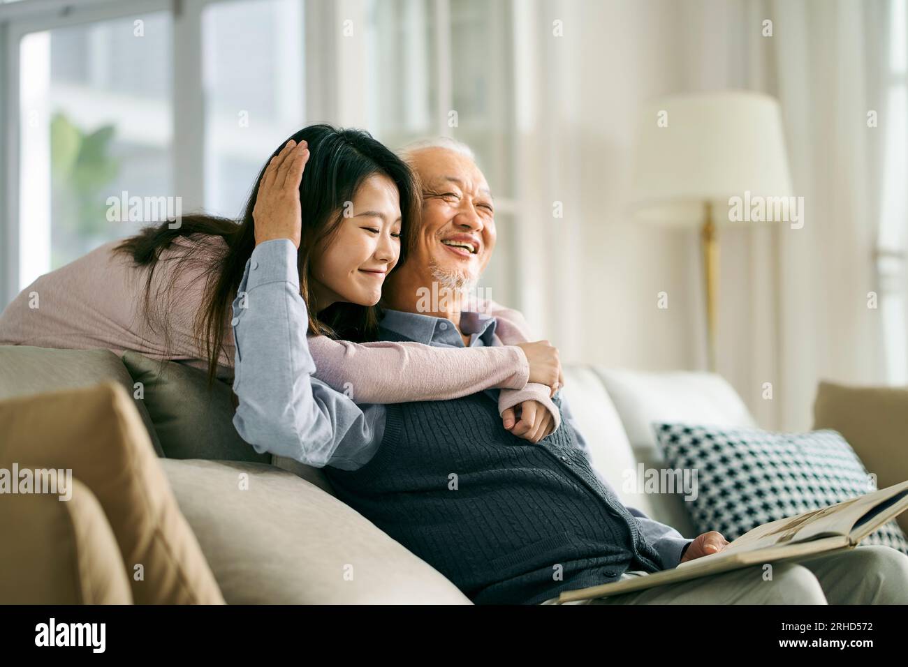 figlia asiatica adulta e padre anziano che si divertono a conversare e a divertirsi a casa Foto Stock