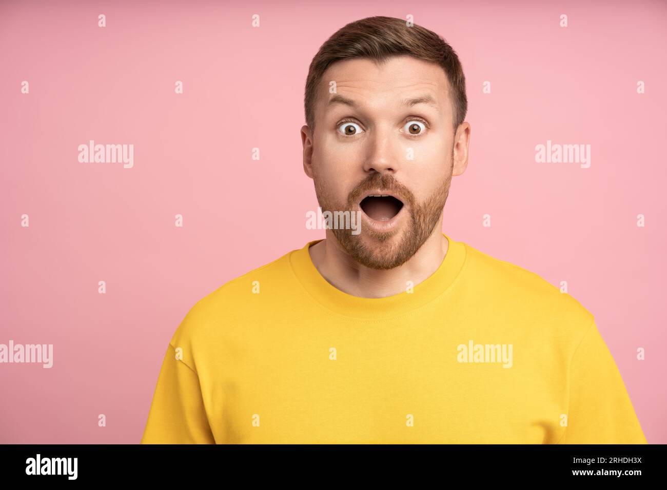 Stupito, eccitato e meravigliato uomo che guarda la fotocamera con un'espressione del volto sorprendente che si sente sorpreso Foto Stock