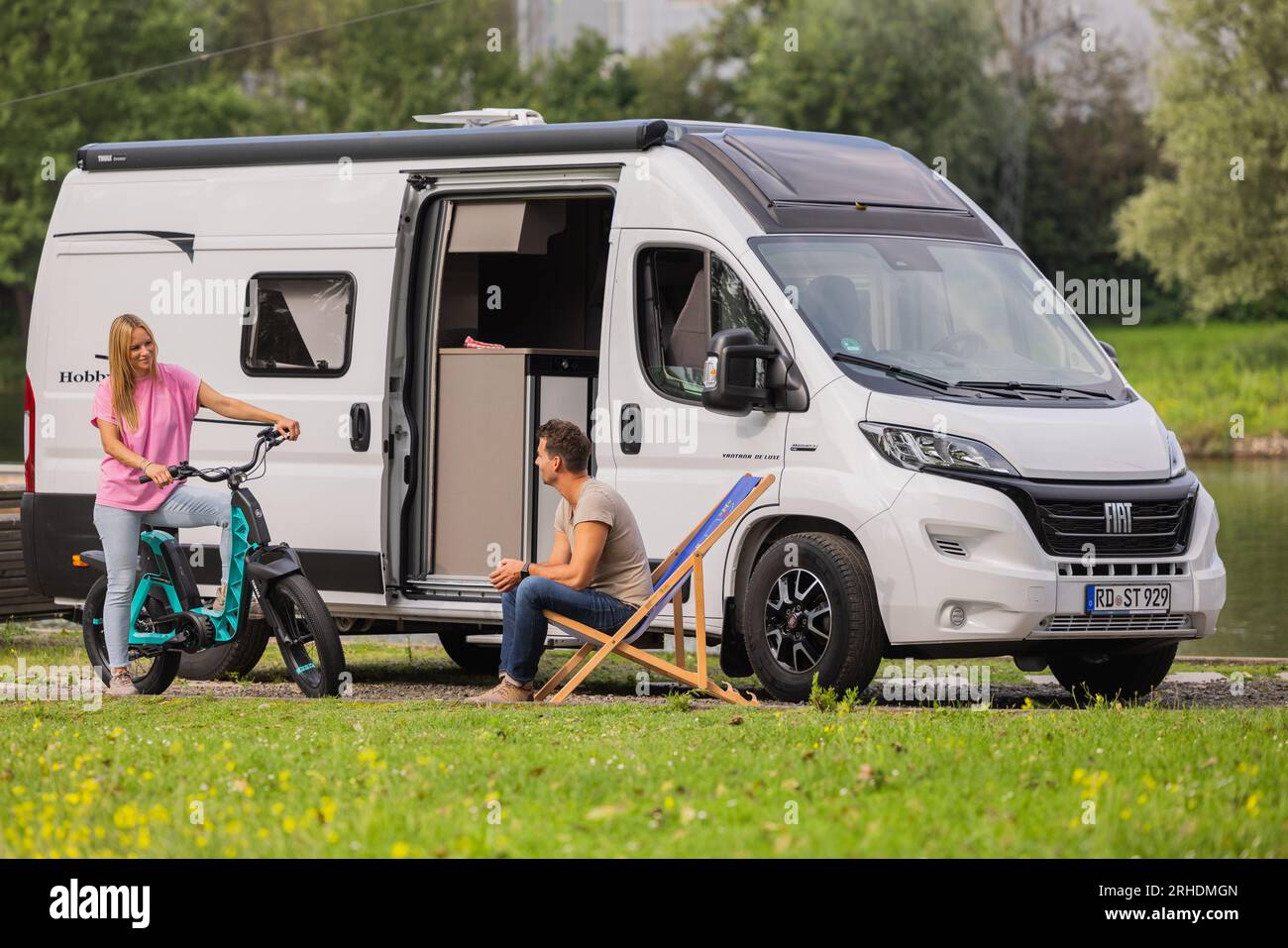 Duisburg, Germania. 16 agosto 2023. I modelli Ralf e Isabell si trovano di fronte al Vantana De Luxe K65 ET motorhome (box van) di Hobby durante una sessione fotografica in vista del Caravan Salon presso l'impianto di sci d'acqua. Il "Caravan Salon" è la più grande fiera al mondo per camper e roulotte e si terrà dal 26 agosto al 3 settembre 2023. Alla 62a edizione sono attesi circa 750 espositori. Il motto dell'edizione di quest'anno è "passione che connette". Crediti: Rolf Vennenbernd/dpa/Alamy Live News Foto Stock