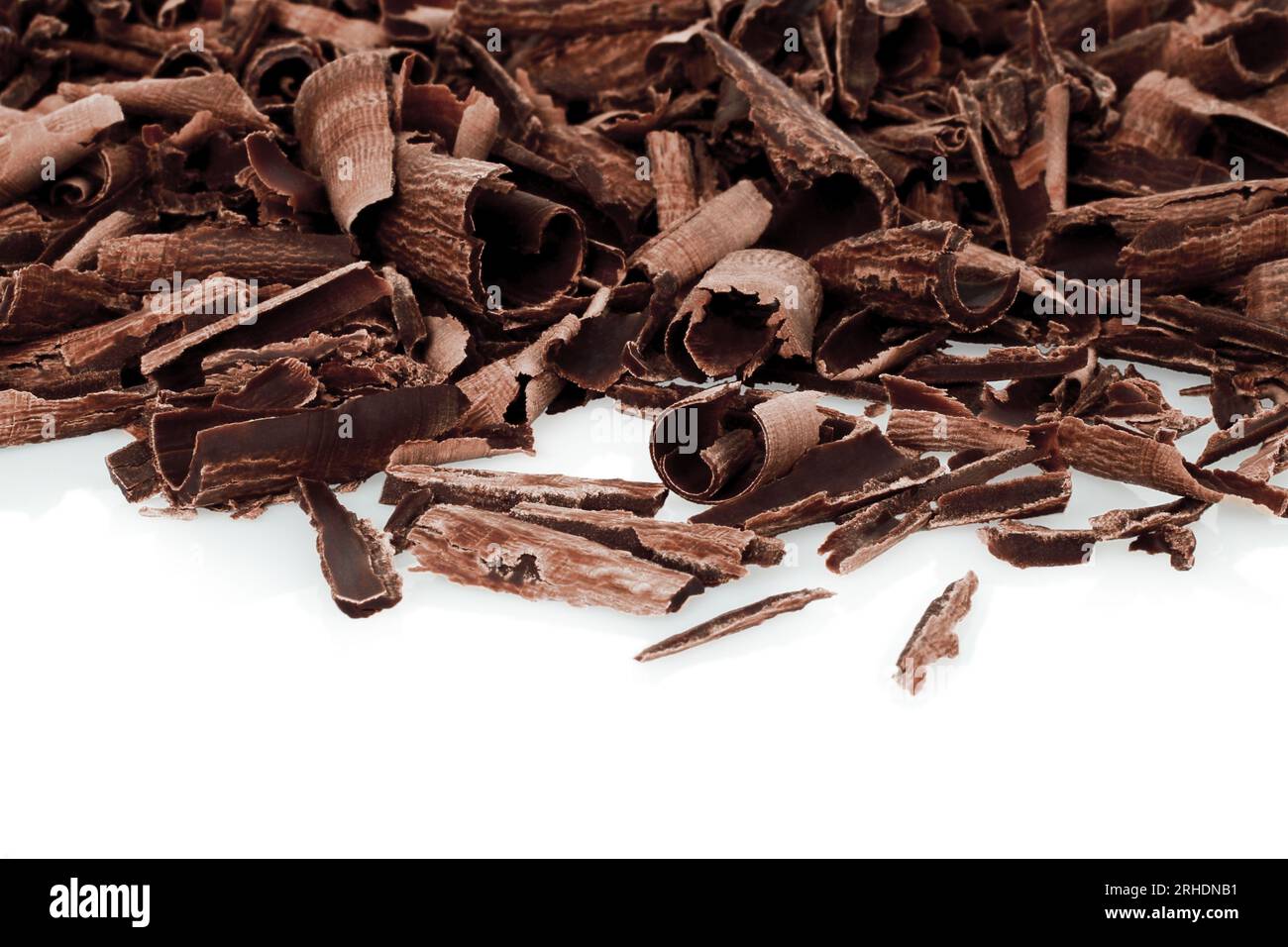Primi piani dei ricci di cioccolato sparso, su sfondo bianco Foto Stock