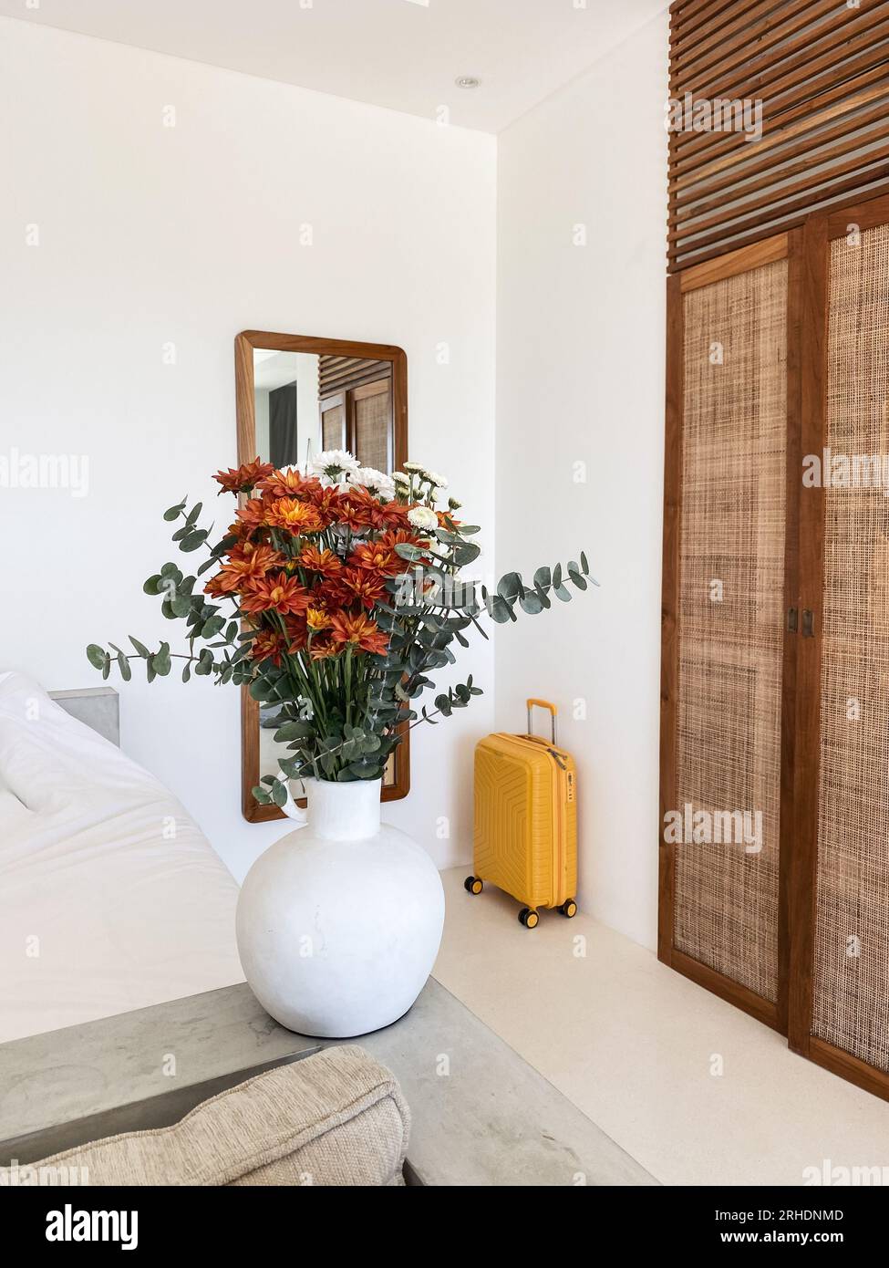 Bouquet di crisantemi arancioni con foglie di eucalipto e valigia gialla all'interno Foto Stock
