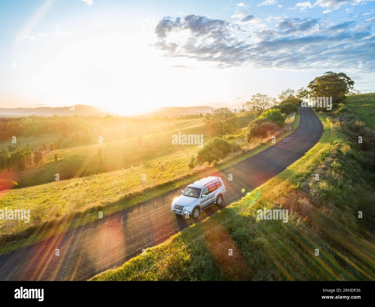 concetto di assicurazione di viaggio con auto su strada di campagna al tramonto in avventura di viaggio su strada Foto Stock