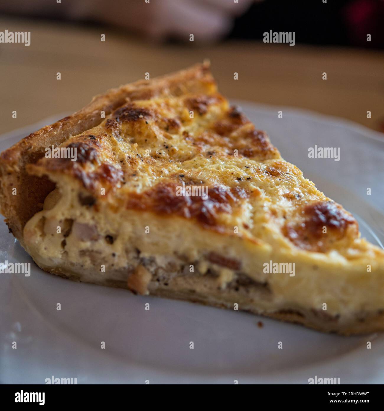 Fetta di Quiche su piatto bianco al ristorante francese Foto Stock