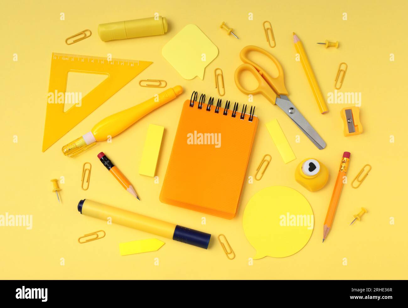 Materiale scolastico e per ufficio su sfondo giallo, vista dall'alto simulata, primo piano del concetto monocromatico Foto Stock