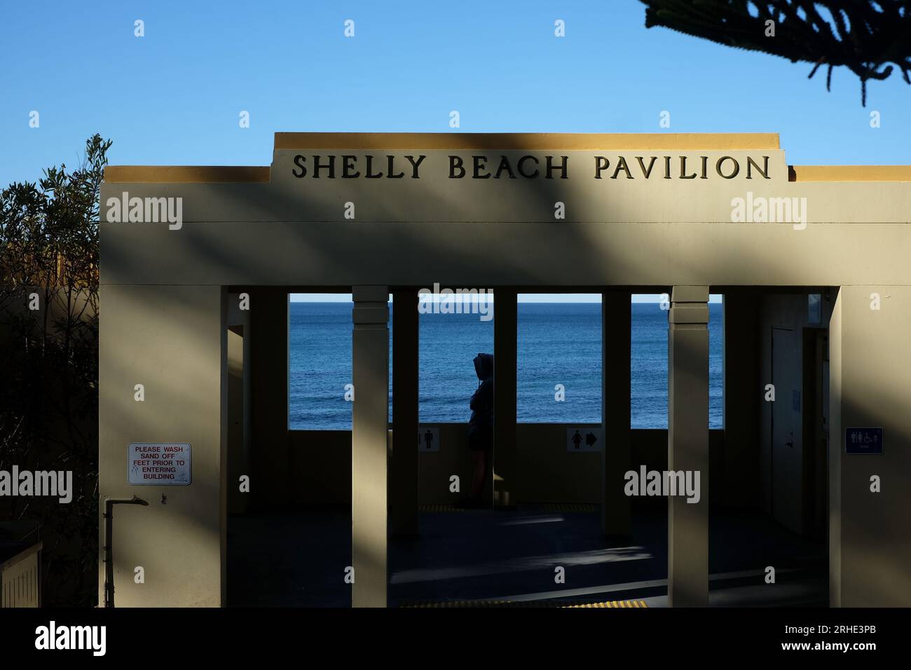 Shelly Beach Pavilion, il semplice padiglione sulla spiaggia di ispirazione art déco nella luce del pomeriggio, limone, giallo contro blu mare e blu chiaro Foto Stock