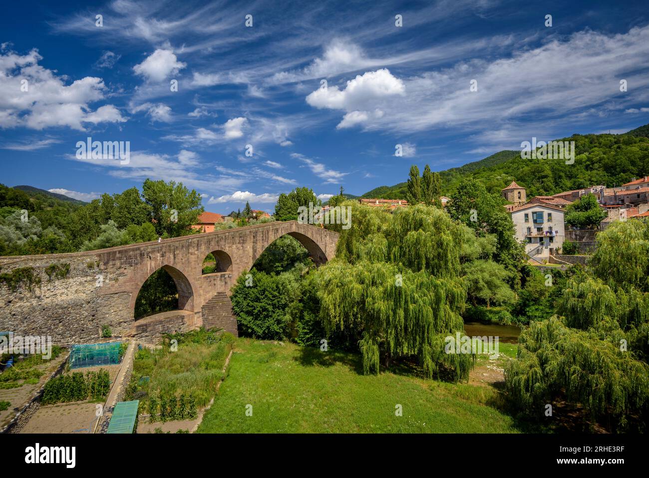 L'antico ponte medievale che attraversa il fiume ter a Sant Joan de les Abadesses, con la città sullo sfondo (Ripollès, Girona, Catalogna, Spagna) Foto Stock