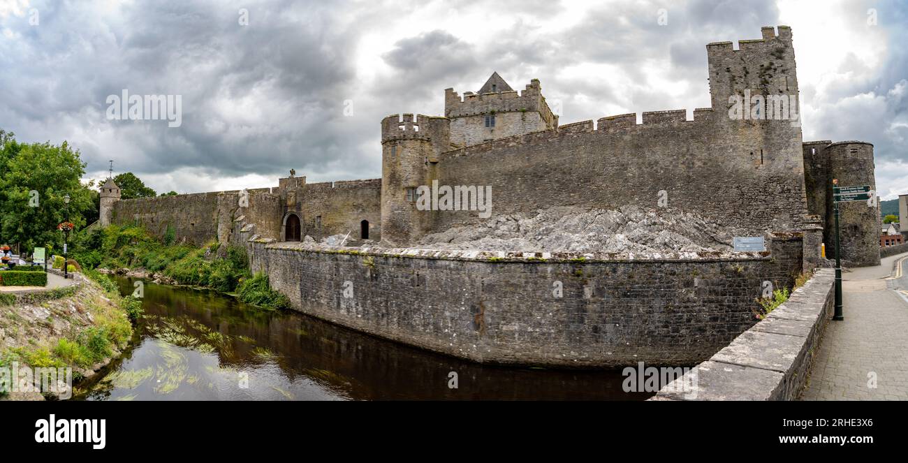 Vista aerea del castello di Cahir e della città in Irlanda con Tower House, castello esterno, torri circolari e rettangolari, sala banchetti, a guardia dell'attraversamento Foto Stock