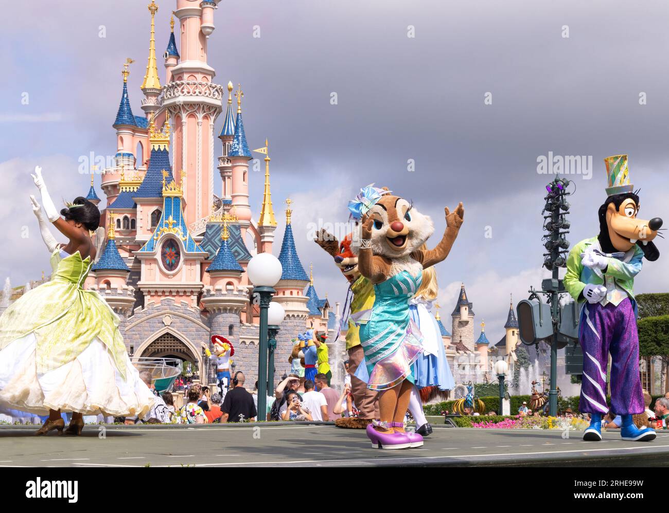 Disneyland Paris; personaggi Disney di fronte al castello di Disneyland che ballano durante la parata di Disneyland; Principessa Tiana, Clarice e Pippo; Francia Foto Stock