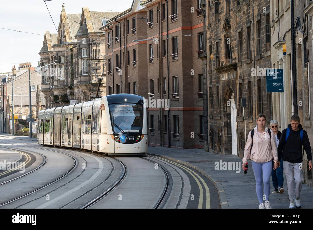 Tram di Edimburgo che corre su Constitution Street a Leith, Edimburgo, Scozia, Regno Unito Foto Stock