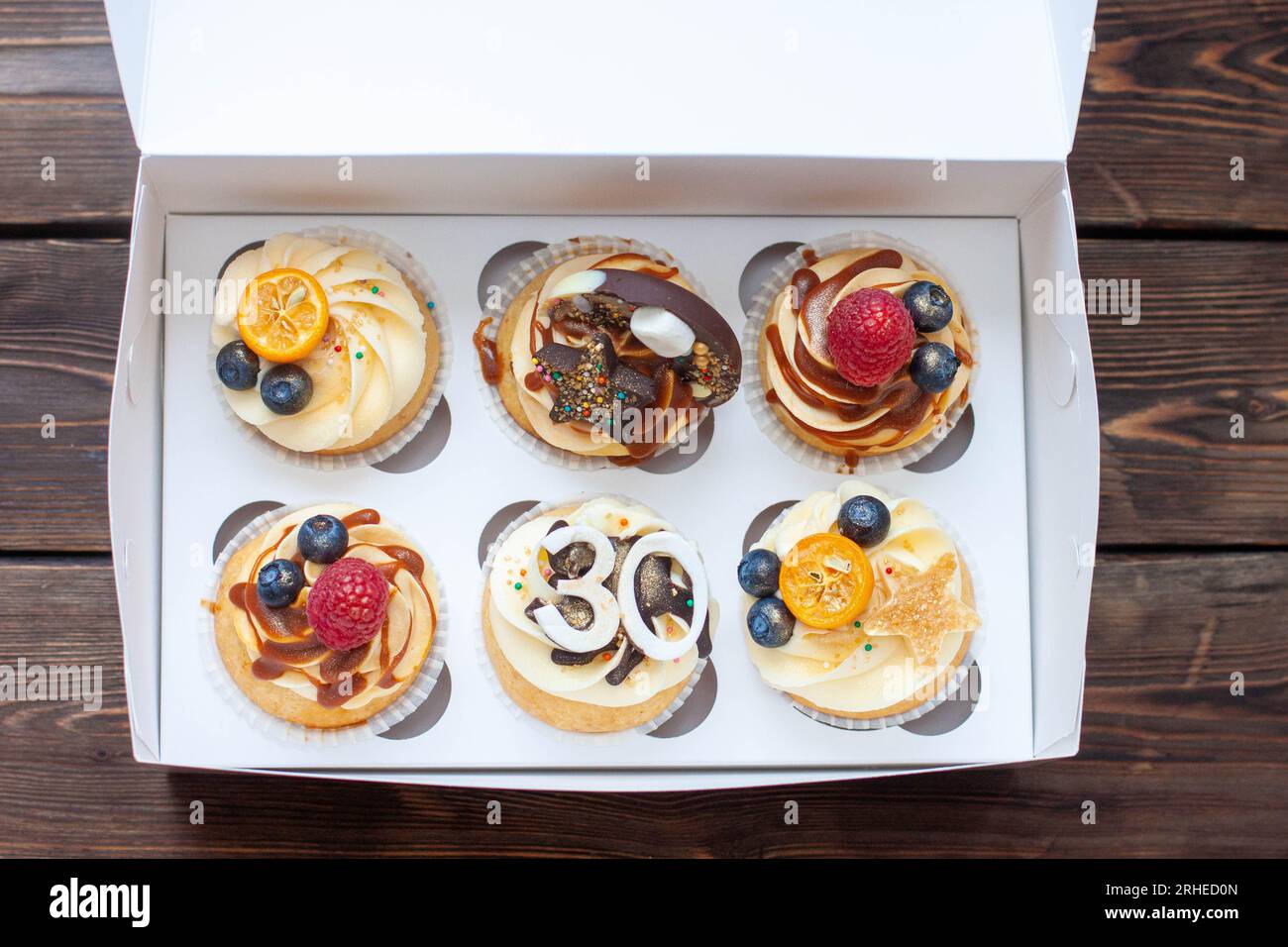 Cupcake natalizi in scatola di cartone con frutti di bosco per un anniversario di 30 anni Foto Stock