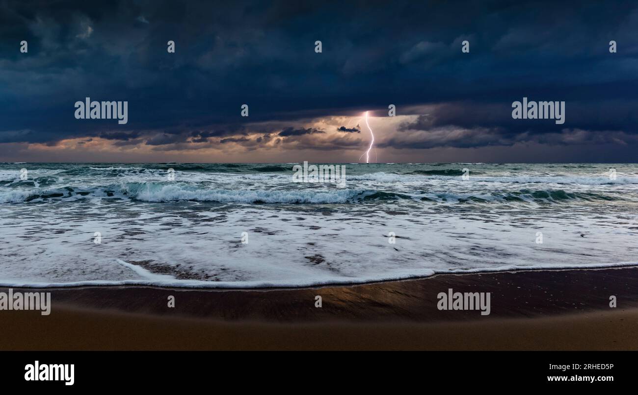 Un incredibile cielo buio e un fulmine sul mare Foto Stock