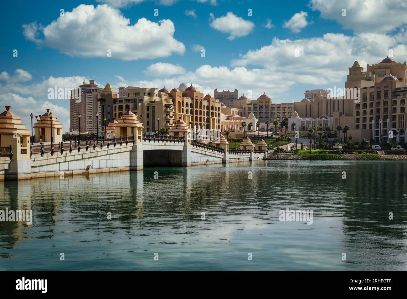 Perla di tranquillità: Le acque calme e fresche dello squisito paesaggio urbano di Pearl Qatar riflettono la bellezza della città, creando un'oasi serena. Foto Stock