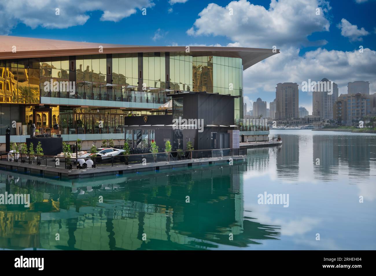 Perla di tranquillità: Le acque calme e fresche dello squisito paesaggio urbano di Pearl Qatar riflettono la bellezza della città, creando un'oasi serena. Foto Stock