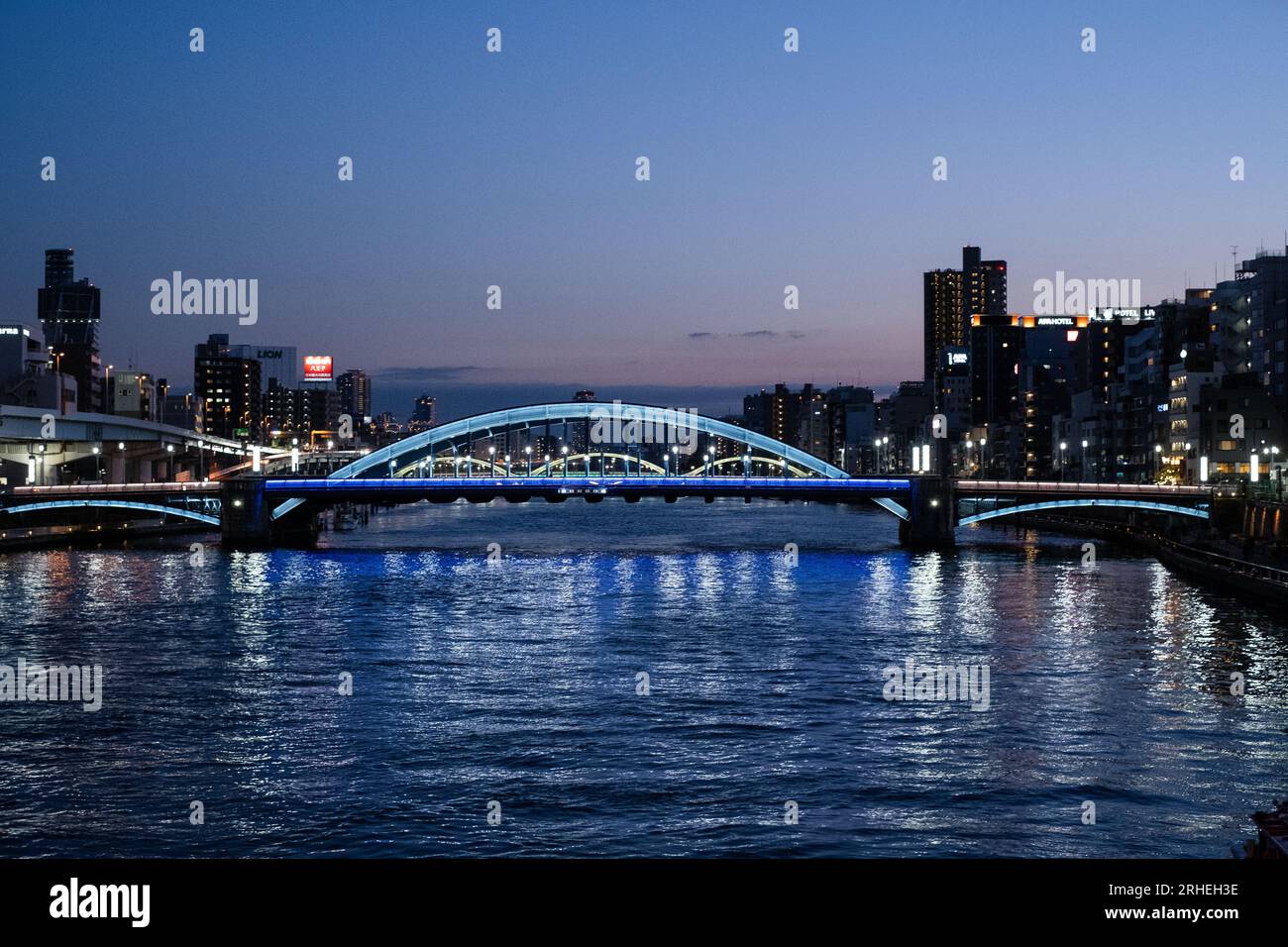 Vista lungo il fiume Sumida, Asakusa, Tokyo, Giappone di notte, con ponti illuminati. Foto Stock