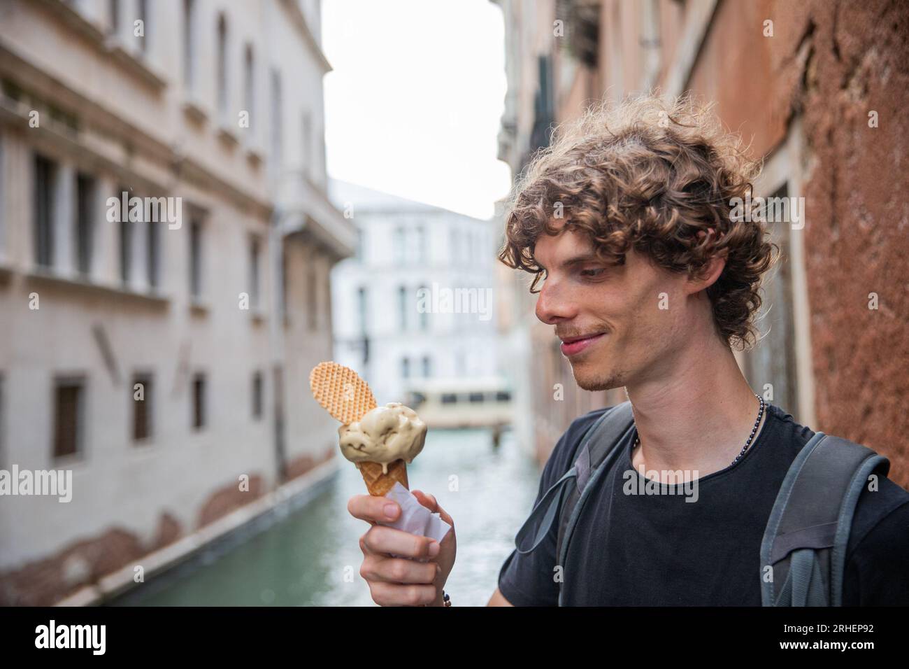 Un turista mangia un gelato mentre è in vacanza a Venezia durante l'estate Foto Stock