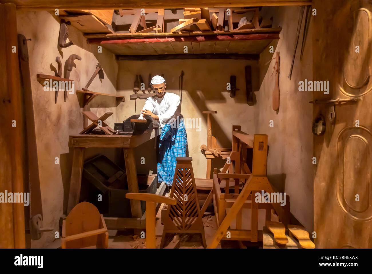 Museo del Bahrain: Stalla di legno. Uomo che lavora all'installazione del legno Foto Stock